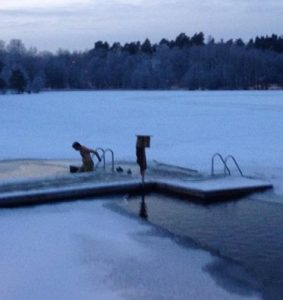 image shows man about to swim in a frozen lake