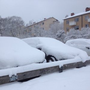 image shows cars completely covered in snow