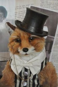 image shows a distinguished fox in a top hat and monocle