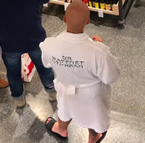 image shows man in bathrobe in line at the liquor store