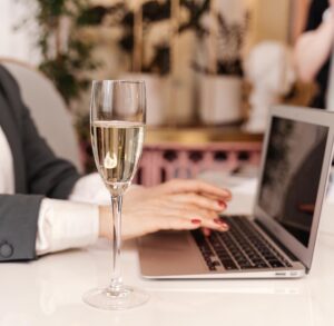 image shows a glass of champagne on a work desk