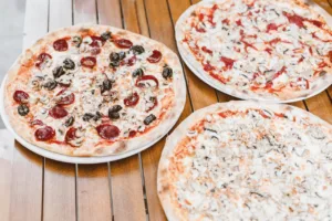 image shows many pizzas