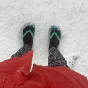 image shows person wearing flip flops in the snow