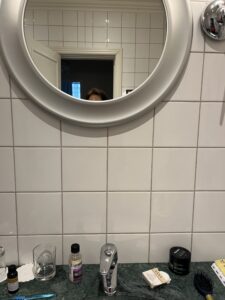 image of the top of my head in a bathroom mirror that I am too short to reach.